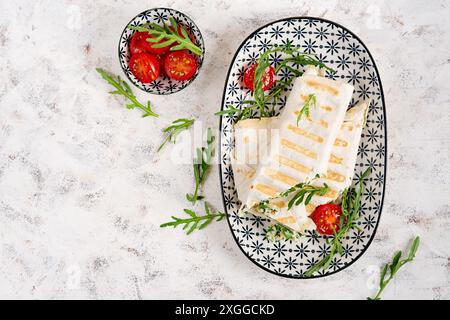 Leckeres Frühstück mit Lavash. Mexikanische Küche. Trendgerichte mit Pitabrot, Käse, Tomaten und Spinat. Draufsicht Stockfoto