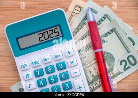 2025 Zahlen auf einem Taschenrechner und Dollarscheine, Neujahrsfinanzierung, Geld- und Budgetdarstellung Stockfoto