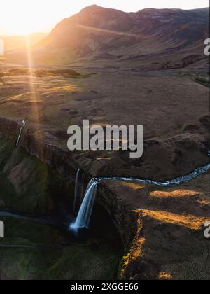 Blick von oben, atemberaubender Blick aus der Luft auf den Seljalandsfoss Wasserfall bei Sonnenuntergang. Seljalandsfoss ist einer der beeindruckendsten Wasserfälle des Landes. Stockfoto