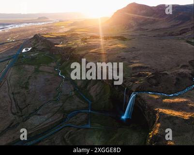 Blick von oben, atemberaubender Blick aus der Luft auf den Seljalandsfoss Wasserfall bei Sonnenuntergang. Seljalandsfoss ist einer der beeindruckendsten Wasserfälle des Landes. Stockfoto