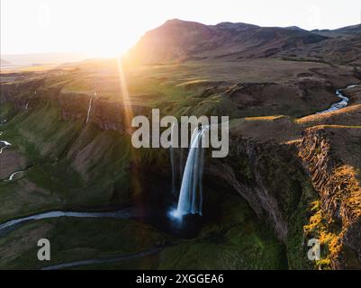 Blick von oben, atemberaubender Blick aus der Luft auf den Seljalandsfoss Wasserfall bei Sonnenuntergang. Seljalandsfoss ist einer der beeindruckendsten Wasserfälle des Landes. Stockfoto