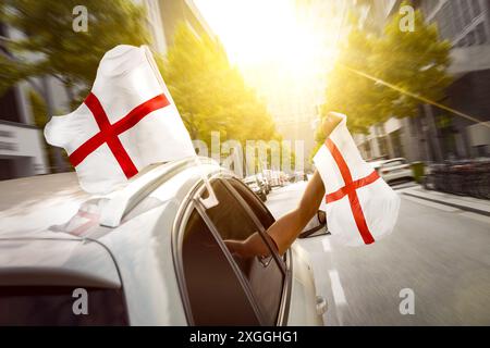 Fans mit englischer Flagge feiern in einem Auto Stockfoto