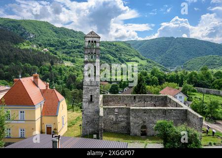 Blick auf die Ruinen der Marienkirche und den Lukas-Glockenturm in der Altstadt von Jajce mit der bosnischen Landschaft im Hintergrund. Stockfoto