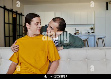 Ein junges schwules Paar teilt einen zärtlichen Moment in einem modernen Apartment und zeigt seine Liebe und Verbundenheit. Stockfoto