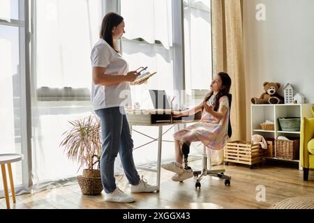 Eine brünette Mutter und ihre Tochter, die eine Beinprothese hat, verbringen Zeit zu Hause. Stockfoto