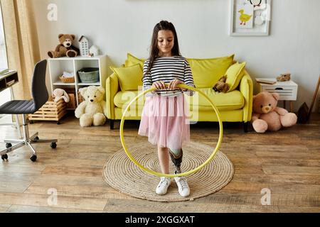 Ein junges Mädchen mit einer Beinprothese spielt mit einem Hula Hoop in ihrem Wohnzimmer. Stockfoto