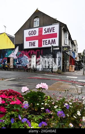 Brighton Großbritannien 9 . Juli 2024 - Ein riesiges „God Save the Team“-Plakat des Künstlers Corbyn Shaw in der Nähe der Lewes Road in Brighton am Tag bevor England im Halbfinalspiel bei der Euro 2024 gegen die Niederlande antritt . Es ist Teil von Buildhollywood, das sich auf kreative Street Advertising Art in britischen Städten spezialisiert hat: Credit Simon Dack / Alamy Live News Stockfoto