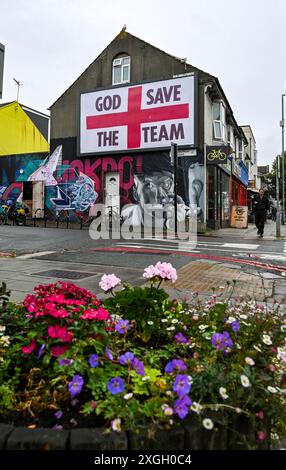 Brighton Großbritannien 9 . Juli 2024 - Ein riesiges „God Save the Team“-Plakat des Künstlers Corbyn Shaw in der Nähe der Lewes Road in Brighton am Tag bevor England im Halbfinalspiel bei der Euro 2024 gegen die Niederlande antritt . Es ist Teil von Buildhollywood, das sich auf kreative Street Advertising Art in britischen Städten spezialisiert hat: Credit Simon Dack / Alamy Live News Stockfoto