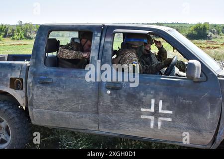 Zaporischzhia, Ukraine. Juli 2024. Ukrainische Soldaten der 15. Brigade (Kara-Dag) der Nationalgarde der Ukraine, die während der Militäraktivitäten im Pickup-Truck gesehen wurden. Die Ukraine und Russland stehen vor einem "tödlichen Sommer", in dem beide Seiten schwere Verluste erleiden und möglicherweise keinen entscheidenden Wendepunkt erreichen können. Für die Ukraine wird es nun die Aufgabe sein, ihre Frontpositionen mit frischen westlichen Waffen zu halten. Im Gegenzug wird Russland weiterhin seine übliche Taktik anwenden: Fleischangriffe für kleine Erfolge. Quelle: SOPA Images Limited/Alamy Live News Stockfoto