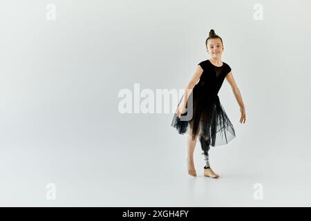 Ein junges Mädchen mit einer Beinprothese führt eine anmutige Gymnastikpose aus. Stockfoto