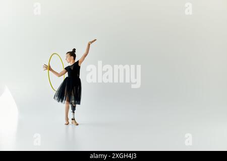 Eine junge Turnerin mit einer Beinprothese führt eine anmutige Basketballroutine in einem Studio aus. Stockfoto