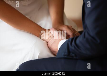 Braut und Bräutigam halten Hände, symbolisieren Liebe und Verbundenheit während der Hochzeitszeremonie Stockfoto