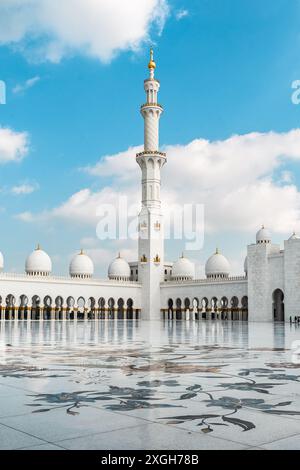 Abu Dhabi, VAE – 4. Januar 2024: Ein elegantes Minarett erhebt sich über der Scheich-Zayed-Moschee und zeigt islamische Architektur vor einem blauen Himmel. Stockfoto