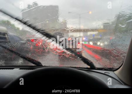 Starker Regen, Sicht ist schwierig. Schalten Sie den Scheibenwischer ein, um das Problem zu lösen. Damit du die Vorderseite sehen kannst. Das Problem ist ein Stau im Verkehr Stockfoto