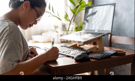 Lächelnde junge Frau aus den 30er Jahren in Brille, die auf den Smartphone-Bildschirm schaut, sich mit dem schnellen, sicheren Online-Service zufrieden fühlt, Haushaltsrechnungen Steuern bezahlt oder rein Stockfoto