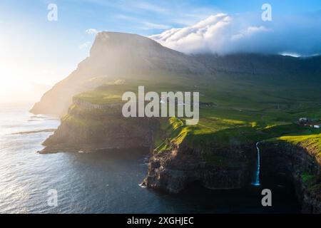 Blick aus der Vogelperspektive auf den Mulafossur-Wasserfall mit dem kleinen Dorf Gasadalur. Vagar Island, Färöer Inseln, Dänemark, Europa. Stockfoto