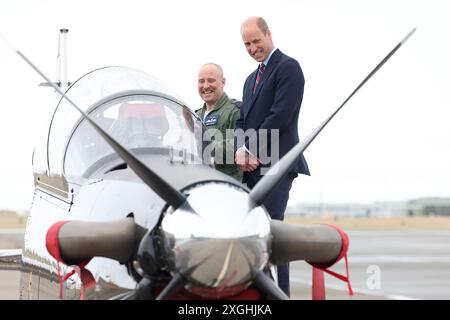 Der Prince of Wales, Royal Honorary Air Commodore, RAF Valley, (rechts) erhält eine Einführung in ein kurzes Tucano-Trainingsflugzeug der RAF während eines Besuchs auf dem RAF Valley Luftwaffenstützpunkt in Anglesey, zum ersten Mal seit der Übernahme der Rolle von König Charles III. Bilddatum: Dienstag, 9. Juli 2024. Stockfoto