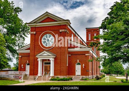 Die Fort Knox Historic Chapel mit einem runden Fenster und weißen Säulen an einem bewölkten Tag, umgeben von üppigen Bäumen Stockfoto