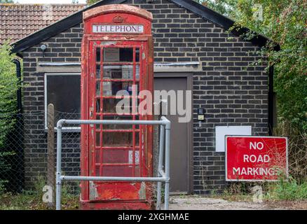 Ein öffentliches rotes Telefonfach in einem Dorf in Suffolk, das scheinbar von British Telecomms vergessen wurde, nach der abblätternden Farbe und dem schlechten Reparaturzustand zu urteilen Stockfoto