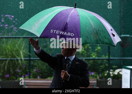 Juli 2024; All England Lawn Tennis and Croquet Club, London, England; Wimbledon Tennis Tournament, Tag 9; Wimbledon Steward versucht, die Zuschauer während des starken Regens in Richtung Centre Court zu lenken Stockfoto