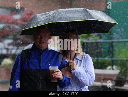 Juli 2024; All England Lawn Tennis and Croquet Club, London, England; Wimbledon Tennis Tournament, Tag 9; Zuschauer in Wimbledon versuchen, unter dem starken Regen trocken zu bleiben Stockfoto