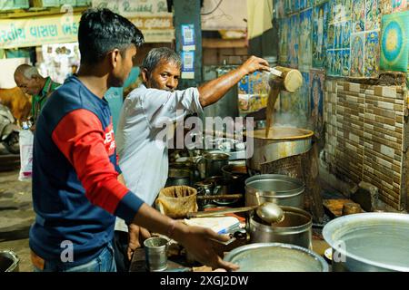 Ahmenabad, Indien - 20. Oktober 2023: Ein Straßenhändler wird nachts Chai verkauft. Alter indianer, der informelle Arbeit macht, Lebensgrundlagen in in Stockfoto