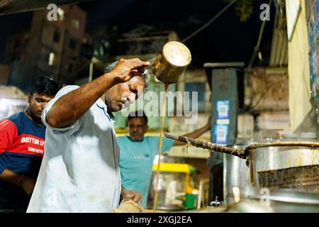 Ahmenabad, Indien - 20. Oktober 2023: Ein Straßenhändler wird nachts Chai verkauft. Alter indianer, der informelle Arbeit macht, Lebensgrundlagen in in Stockfoto