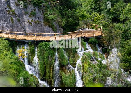 Perlmuttarer blauer Wasserfall mit Holzweg in den Plitvicer Seen Kroatien Stockfoto