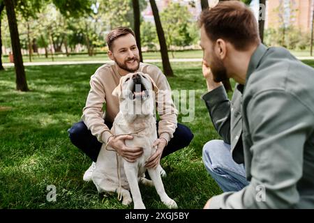 Ein bärtiges schwules Paar genießt einen sonnigen Nachmittag im Park mit seinem labrador Retriever. Stockfoto