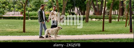 Ein bärtiges Schwulenpaar spaziert Hand in Hand mit ihrem labrador Retriever an einem sonnigen Tag durch einen üppigen grünen Park. Stockfoto