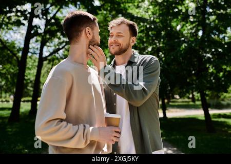 Ein bärtiges Schwulenpaar genießt einen sonnigen Nachmittag in einem grünen Park. Stockfoto