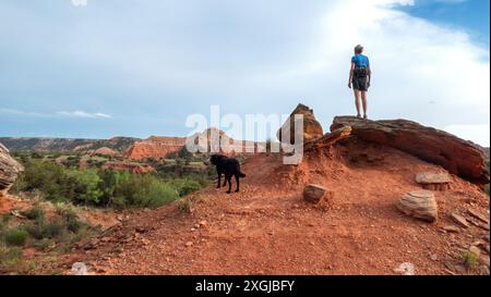 Eine alleinstehende Frau und ihr schwarzes Labor wandern im Palo Duro Canyon State Park, Texas. Stockfoto