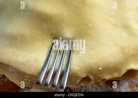 Torte machen: Oberste Kruste. Schließen Sie den Kreis, der mit einer Gabel versiegelt wird, indem Sie die Kanten zusammendrücken. Stockfoto