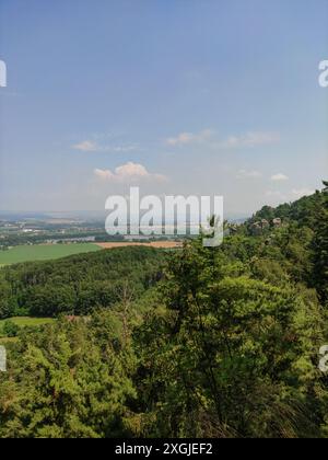Ein Panoramablick auf eine bewaldete Landschaft mit sanften Hügeln und einem blauen Himmel mit Wolken. Vertikales mobiles Foto. Sstkvertical Stockfoto
