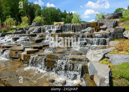 Wasser fließt über Felsen in einem kaskadierenden Wasserfall. Spazieren Sie im Park. Stockfoto