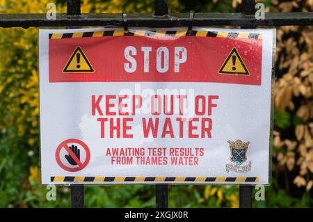 Chalfont St Peter, Großbritannien. Juli 2024. Neben dem Fluss Misbourne in Chalfont St Peter, Buckinghamshire, wurden Schilder angebracht, die die Menschen raten, sich vom Wasser fernzuhalten. Seit Januar dieses Jahres leitet die Themse über 3.500 Stunden Abwasser aus den Amersham Balacing Tanks in den River Misbourne. Der Misbourne ist ein wertvoller Kreidefluss, der durch Chalfont St Giles und Chalfont St Peter verläuft. Der Abwasserüberlauf wurde auch in der ersten Jahreshälfte von der Themse in Chalfont St Peter nach Überschwemmungen und einem Anstieg des Grundwassers in den Misbourne gepumpt Stockfoto