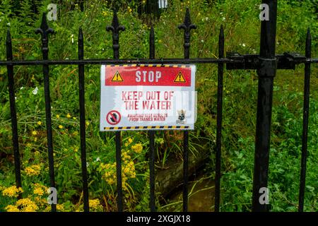 Chalfont St Peter, Großbritannien. Juli 2024. Neben dem Fluss Misbourne in Chalfont St Peter, Buckinghamshire, wurden Schilder angebracht, die die Menschen raten, sich vom Wasser fernzuhalten. Seit Januar dieses Jahres leitet die Themse über 3.500 Stunden Abwasser aus den Amersham Balacing Tanks in den River Misbourne. Der Misbourne ist ein wertvoller Kreidefluss, der durch Chalfont St Giles und Chalfont St Peter verläuft. Der Abwasserüberlauf wurde auch in der ersten Jahreshälfte von der Themse in Chalfont St Peter nach Überschwemmungen und einem Anstieg des Grundwassers in den Misbourne gepumpt Stockfoto