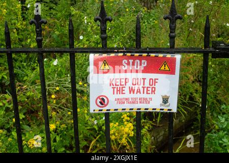 Chalfont St Peter, Großbritannien. Juli 2024. Neben dem Fluss Misbourne in Chalfont St Peter, Buckinghamshire, wurden Schilder angebracht, die die Menschen raten, sich vom Wasser fernzuhalten. Seit Januar dieses Jahres leitet die Themse über 3.500 Stunden Abwasser aus den Amersham Balacing Tanks in den River Misbourne. Der Misbourne ist ein wertvoller Kreidefluss, der durch Chalfont St Giles und Chalfont St Peter verläuft. Der Abwasserüberlauf wurde auch in der ersten Jahreshälfte von der Themse in Chalfont St Peter nach Überschwemmungen und einem Anstieg des Grundwassers in den Misbourne gepumpt Stockfoto