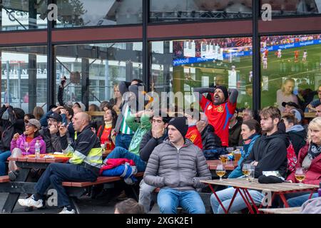 Fußballfans verfolgen anlässlich der Fußball-Europameisterschaft UEFA EURO 2024 das Halblfinalspiel Spanien gegen Frankreich auf einer Leinwand auf dem Platz Hlemmur in Rsykajvik. / Fußballfans sehen das Halbfinalspiel zwischen Spanien und Frankreich auf einem Bildschirm auf dem Hlemmur-Platz in Rsykajvik während der UEFA EURO 2024 Fußball-Europameisterschaft. UEFA Fußball-Europameisterschaft - Fußballfans *** Fußballfans sehen das Halbfinalspiel zwischen Spanien und Frankreich auf einem Bildschirm auf dem Hlemmur-Platz in Rsykajvik während der UEFA EURO 2024 Fußball-Europameisterschaft der UEFA so Stockfoto