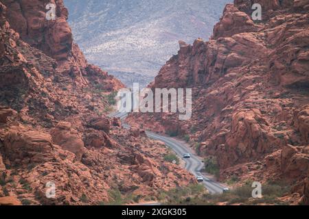 Eine Straße schlängelt sich durch einen Canyon mit ein paar Autos. Die Szene ist friedlich und ruhig, mit den Bergen im Hintergrund, die das Gefühl von Kal verstärken Stockfoto