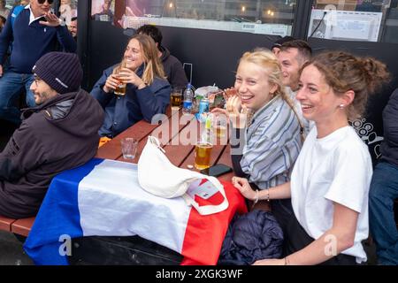 Fußballfans verfolgen anlässlich der Fußball-Europameisterschaft UEFA EURO 2024 das Halblfinalspiel Spanien gegen Frankreich auf einer Leinwand auf dem Platz Hlemmur in Rsykajvik. / Fußballfans sehen das Halbfinalspiel zwischen Spanien und Frankreich auf einem Bildschirm auf dem Hlemmur-Platz in Rsykajvik während der UEFA EURO 2024 Fußball-Europameisterschaft. UEFA Fußball-Europameisterschaft - Fußballfans *** Fußballfans sehen das Halbfinalspiel zwischen Spanien und Frankreich auf einem Bildschirm auf dem Hlemmur-Platz in Rsykajvik während der UEFA EURO 2024 Fußball-Europameisterschaft der UEFA so Stockfoto