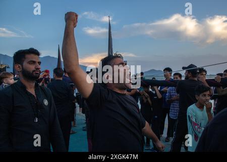 Srinagar, Indien. Juli 2024. Ein Mann aus Kaschmir schiitischer Muslime ruft an der Uferstraße in Srinagar religiöse Slogans. Muharram ist der erste Monat des islamischen Kalenders. Es ist einer der heiligsten Monate im islamischen Kalender. Schiitische Muslime gedenken Muharram als einen Monat der Trauer zum Gedenken an das Martyrium des islamischen Propheten Muhammads Enkel Imam Hussain, der 680 n. Chr. auf Ashura (10. Tag Muharram) in der Schlacht von Karbala getötet wurde Stockfoto