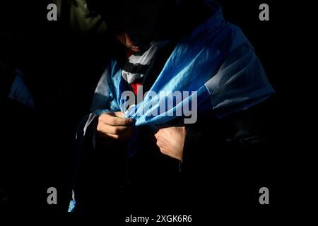 Buenos Aires, Argentinien. Juli 2024. Ein Mann trägt eine argentinische Flagge während einer Militärparade zum Unabhängigkeitstag. Quelle: Cristina Sille/dpa/Alamy Live News Stockfoto