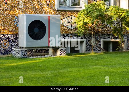 Wärmepumpe im Freien an der Mosaikwand im Garten Stockfoto