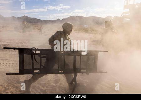 Twentynine Palms, Kalifornien, USA. Juni 2024. Eine U.S. Marine with Truck Company, 25th Marine Regiment, 4th Marine Division, trägt einen Müll zu einem simulierten Unfall, während sie während der Integrierten Trainingsübung 4-24 im Marine Corps Air Ground Combat Center, Twentynine Palms, Kalifornien, am 23. Juni 2024 einen motorisierten Operationskurs durchführt. Der Kurs wurde durchgeführt, um sicherzustellen, dass Marines ausreichende Unterstützung und taktische Logistik in den Bereichen Transport, Wartung und Evakuierung von Unfällen bieten können. ITX ist der Höhepunkt des Trainingszyklus der Marine Forces Reserve Stockfoto