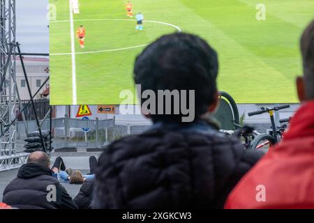 Fußballfans verfolgen anlässlich der Fußball-Europameisterschaft UEFA EURO 2024 das Halblfinalspiel Spanien gegen Frankreich auf einer Leinwand auf dem Platz Hlemmur in Rsykajvik. / Fußballfans sehen das Halbfinalspiel zwischen Spanien und Frankreich auf einem Bildschirm auf dem Hlemmur-Platz in Rsykajvik während der UEFA EURO 2024 Fußball-Europameisterschaft. UEFA Fußball-Europameisterschaft - Fußballfans *** Fußballfans sehen das Halbfinalspiel zwischen Spanien und Frankreich auf einem Bildschirm auf dem Hlemmur-Platz in Rsykajvik während der UEFA EURO 2024 Fußball-Europameisterschaft der UEFA so Stockfoto