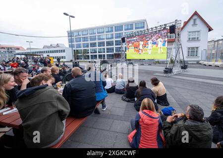 Fußballfans verfolgen anlässlich der Fußball-Europameisterschaft UEFA EURO 2024 das Halblfinalspiel Spanien gegen Frankreich auf einer Leinwand auf dem Platz Hlemmur in Rsykajvik. / Fußballfans sehen das Halbfinalspiel zwischen Spanien und Frankreich auf einem Bildschirm auf dem Hlemmur-Platz in Rsykajvik während der UEFA EURO 2024 Fußball-Europameisterschaft. UEFA Fußball-Europameisterschaft - Fußballfans *** Fußballfans sehen das Halbfinalspiel zwischen Spanien und Frankreich auf einem Bildschirm auf dem Hlemmur-Platz in Rsykajvik während der UEFA EURO 2024 Fußball-Europameisterschaft der UEFA so Stockfoto