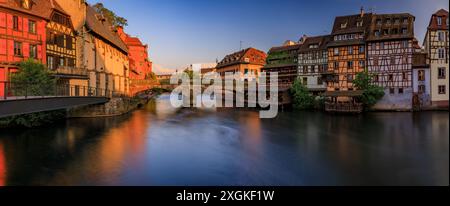 Verzierte traditionelle Fachwerkhäuser mit blühenden Blumen entlang der Kanäle im Viertel Petite France in Straßburg, Elsass, Frankreich bei Sonnenuntergang Stockfoto