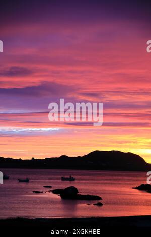 Wetter Iona, Schottland Vereinigtes Königreich 9. Juli 2024: Spektakulärer Sonnenuntergang über der Insel Iona in den Inneren Hebriden Schottlands. Aus Fionnphort, Isle of Mull Stockfoto