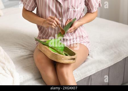 Schöne junge Frau, die zu Hause Aloe Vera Gel herstellt Stockfoto